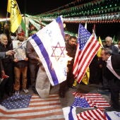 Iraníes queman banderas de Israel y Estados Unidos durante una manifestación antiisraelí en la plaza Palestina de Teherán (Irán)