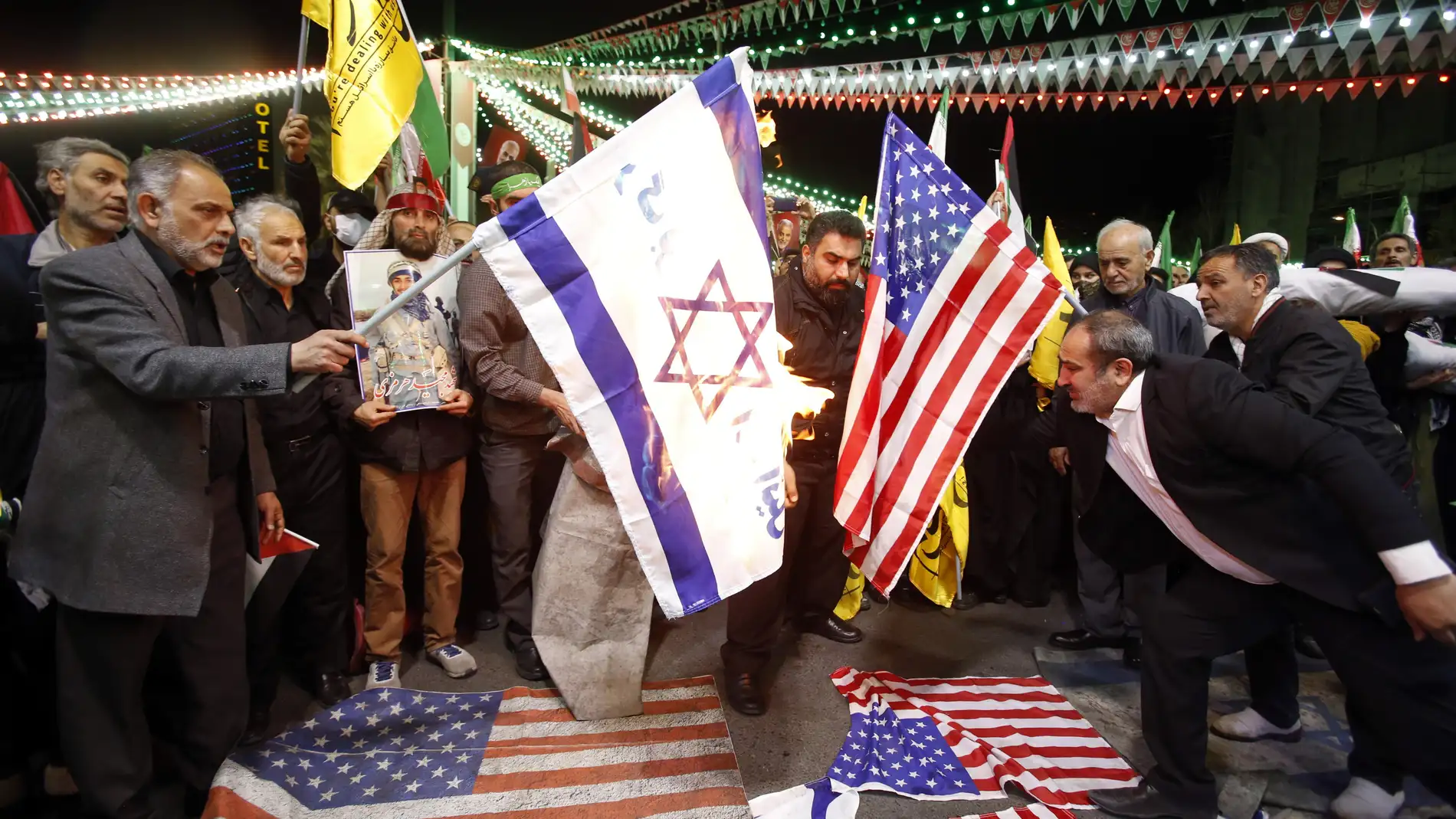 Iraníes queman banderas de Israel y Estados Unidos durante una manifestación antiisraelí en la plaza Palestina de Teherán (Irán)
