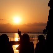 En la imagen de archivo, varias personas contemplan la puesta de sol en la Albufera de Valencia.