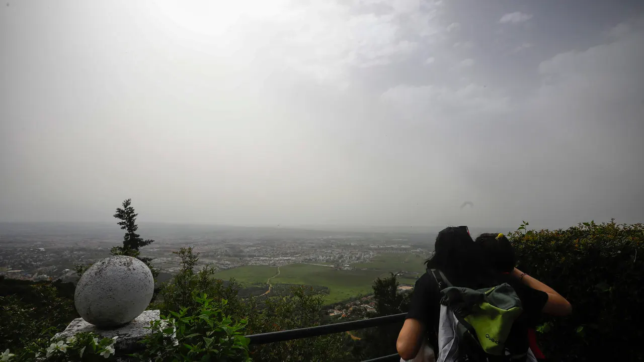 Una persona observa desde el mirador de la sierra la ciudad de Córdoba, poco visible por la calima, este domingo