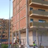 El derrumbe del revestimiento de la fachada de un edificio en Cáceres se salda sin causar daños personales