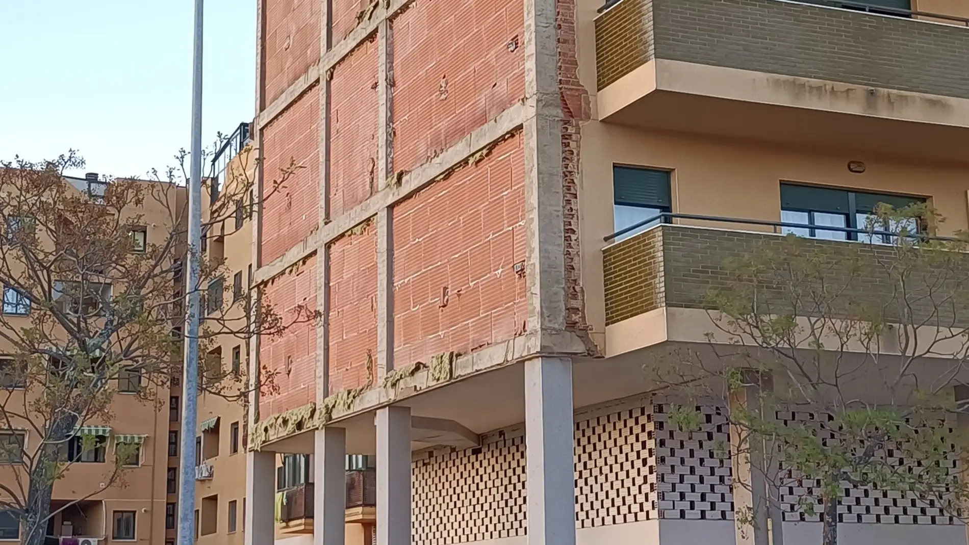 El derrumbe del revestimiento de la fachada de un edificio en Cáceres se salda sin causar daños personales