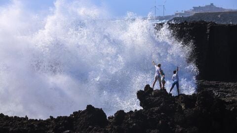 La Dirección General de Emergencias del Gobierno de Canarias ha declarado la situación de alerta, en todo el archipiélago, ante el riesgo de inundación costera por saltos del oleaje a paseos marítimos y carreteras próximos a la línea de costa durante la pleamar. En la imagen, turistas se saltan la prohibición de acercarse al mar, en Los Cancajos, en la isla de La Palma. 