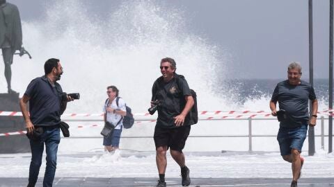 Un grupo de personas escapa de una ola este miércoles en el municipio de Candelaria en Tenerife, durante la alerta por riesgo de inundaciones costeras declarada por la Dirección General de Emergencias del Gobierno de Canarias. 