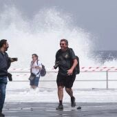 Un grupo de personas escapa de una ola este miércoles en el municipio de Candelaria en Tenerife, durante la alerta por riesgo de inundaciones costeras declarada por la Dirección General de Emergencias del Gobierno de Canarias. 