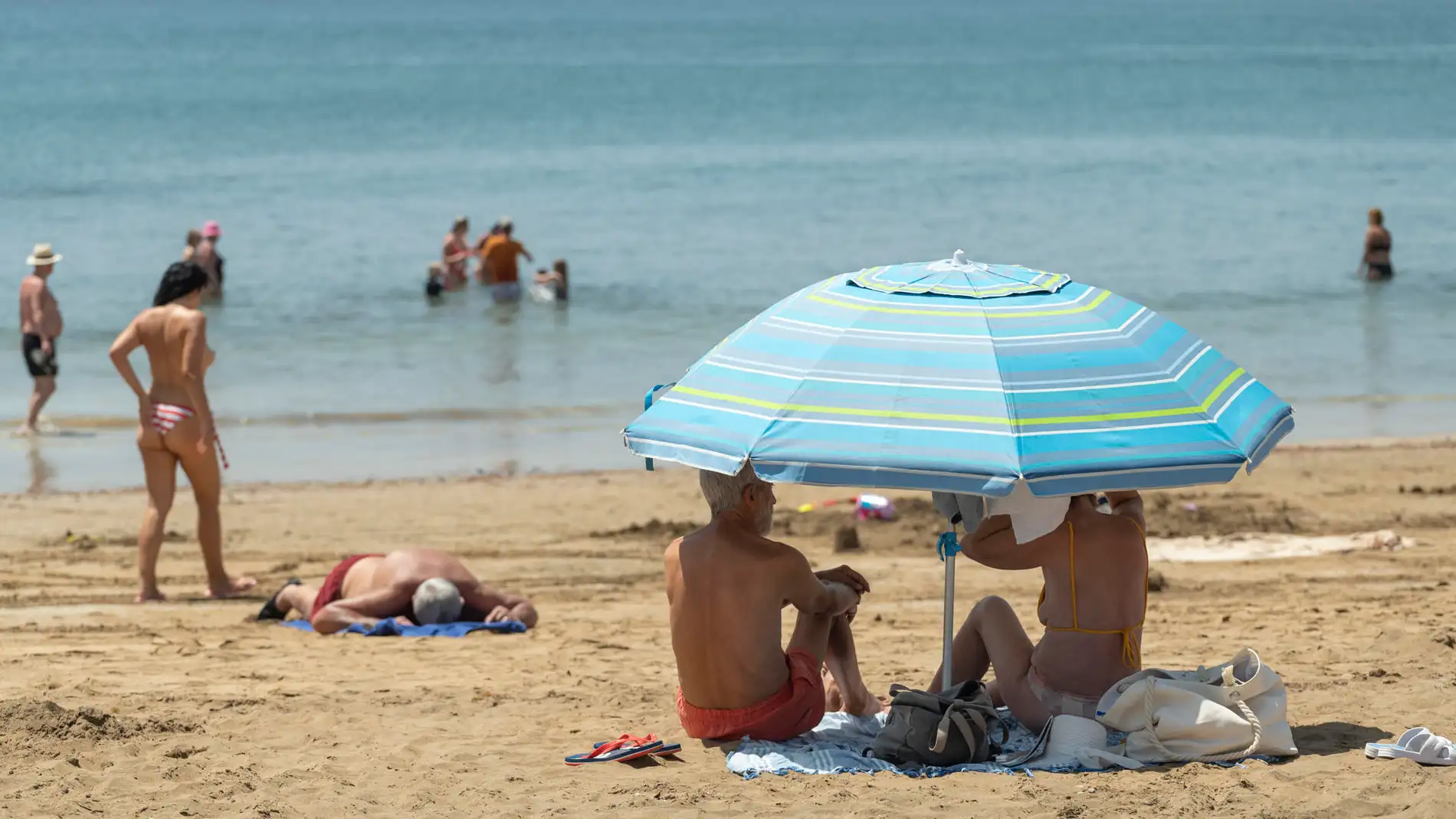 Altas temperaturas y la calima hoy sábado en Lanzarote. Turistas combaten el calor en las playas en Puerto del Carmen, municipio de Tías. 