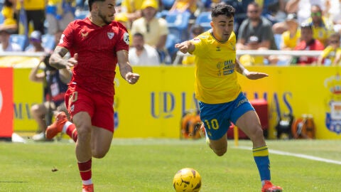 El delantero del Sevilla Isaac Romero y el centrocampista del UD Las Palmas Alberto Moleiro, durante el partido correspondiente a la jornada 31 de LaLiga EA Sports que disputan este domingo en el Estadio de Gran Canaria