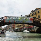 Uno de los canales de Venecia, con un cartel promocionando la Bienal 