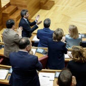 El president de la Generalitat, Carlos Mazón, junto al resto de miembros del grupo popular, aplaude tras la tramitación de las leyes propuestas por el PP y Vox. 