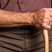 Un anciano sosteniendo un bastón 