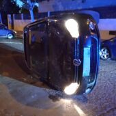 Vehículo volcado tras un accidente en la calle Alfonso Eanes