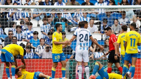 El defensa de la Real Sociedad Robin Le Normand (c) gesticula mientas dos jugadores de la UD Las Palmas se lamentan en el suelo tras una jugada durante el partido de la jornada 34 de LaLiga Ea Sports disputado este s&aacute;bado en el estadio Reale Arena de San Sebasti&aacute;n.