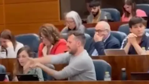 Un diputado de Más Madrid hace el gesto de disparar durante la intervención de Ayuso Un diputado de Más Madrid hace el gesto de disparar durante la intervención de Ayuso