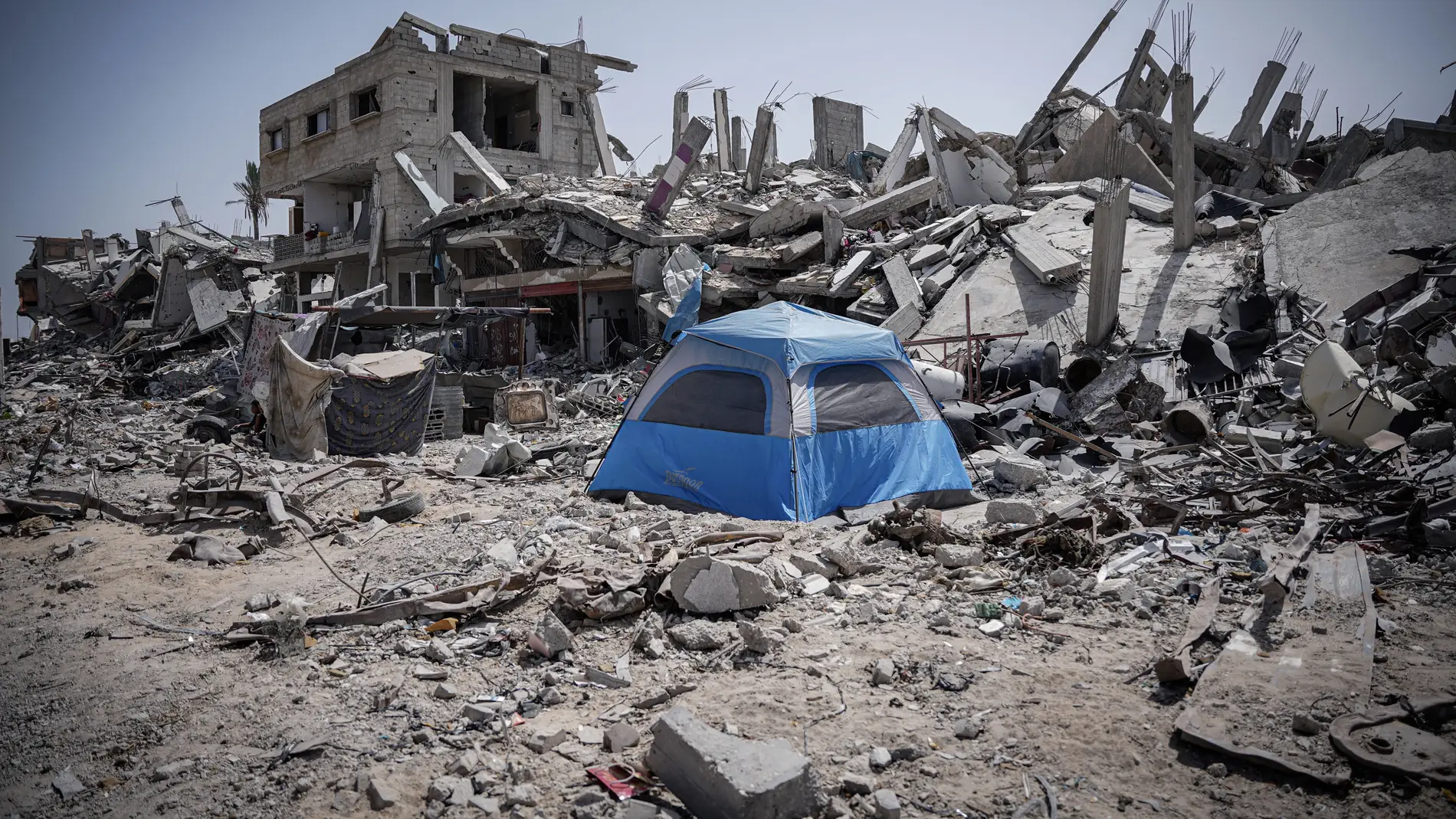 Los palestinos instalan sus tiendas de campaña sobre los escombros de sus casas destruidas en la ciudad de Khan Younis