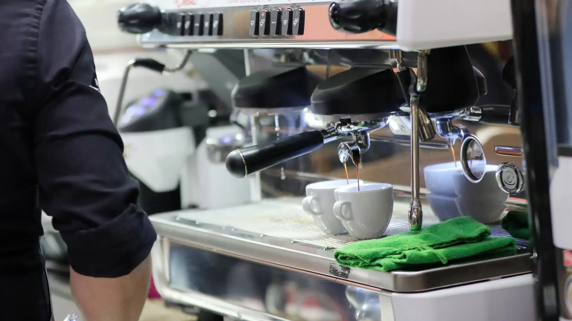 Un camarero prepara café en un bar Un camarero prepara café en un bar