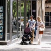 Dos personas observan los anuncios de viviendas en venta en una inmobiliaria en Palma