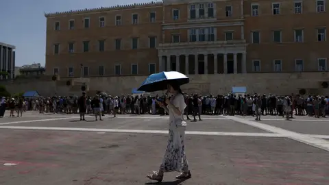 Un turista sostiene un paraguas frente al Monumento al Soldado Desconocido en la Plaza Syntagma Un turista sostiene un paraguas frente al Monumento al Soldado Desconocido en la Plaza Syntagma