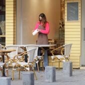 Una dona treballant en la terrassa d'un restaurant en ple Covid.