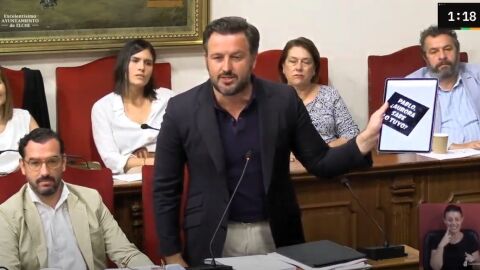 Pablo Ruz, alcalde de Elche, exhibe en el pleno del Ayuntamiento la pegatina que ha denunciado.