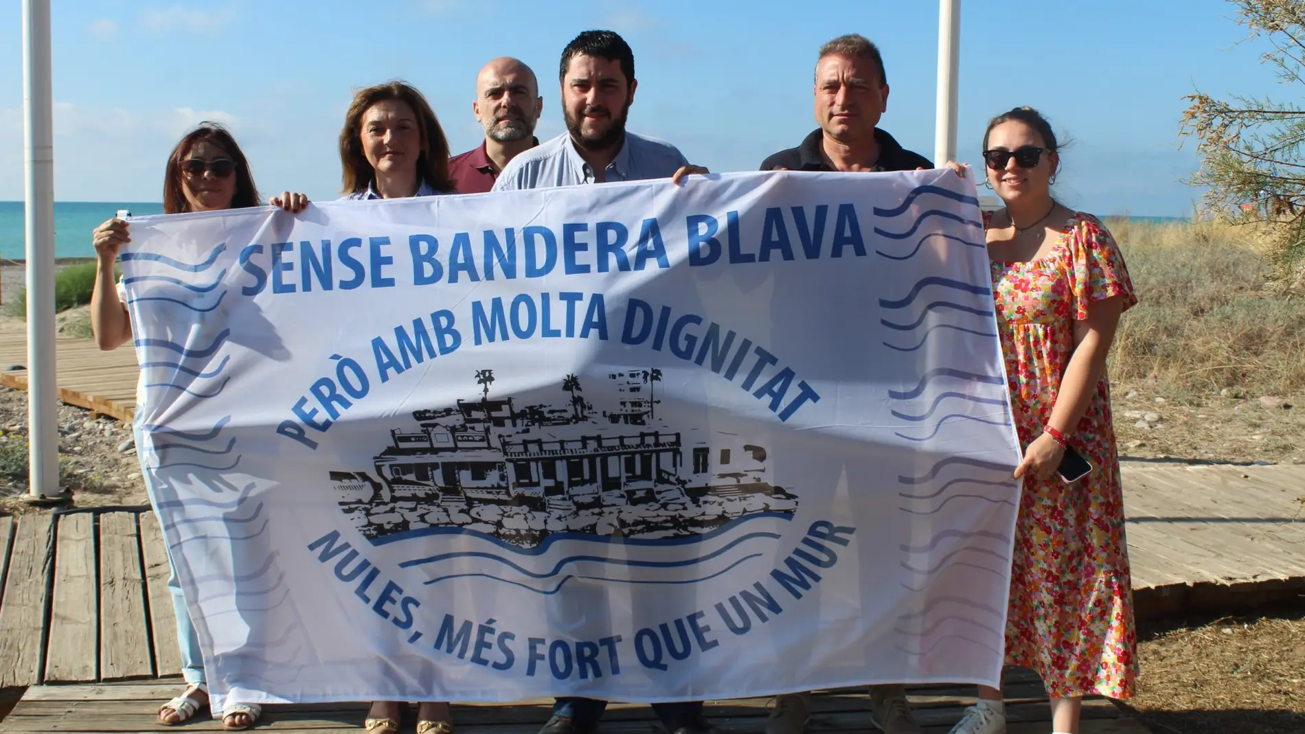El alcalde de Nules, David García, posando con la bandera reivindicativa en la playa Les Marines