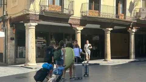 Un grupo de amigas carga sus maletas a su paso por la Plaza del Torico FIESTAS