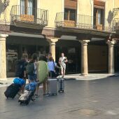 Un grupo de amigas carga sus maletas a su paso por la Plaza del Torico