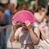 Una mujer se protege del sol con un abanico en Valencia.