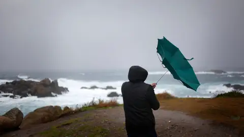 En la imagen de archivo, un hombre ve como el viento le dobla el paraguas en A Coruña Cinco comunidades en alerta naranja (riesgo importante) este domingo por cercanía de la borrasca Bert
