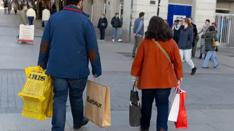 Dos personas pasean con sus compras por las calles de Madrid - Eduardo Parra Dos personas pasean con sus compras por las calles de Madrid - Eduardo Parra
