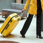 Imagen de archivo de una persona con su maleta en un hotel.