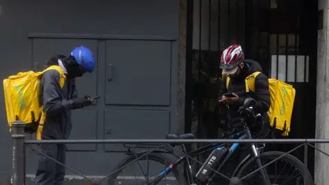 Dos trabajadores de Glovo en hora de servicio Dos trabajadores de Glovo en hora de servicio