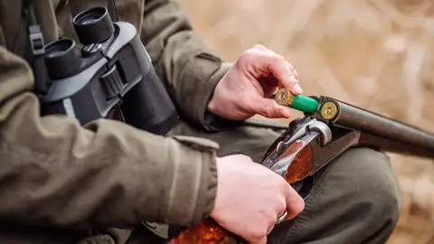 Un cazador carga una escopeta Un cazador carga una escopeta