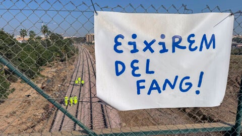 Una pancarta con la frase ¡Saldremos del barro! sobre un grupo de operarios que trabaja en la reconstrucción de las vías del tren de cercanías en Alfafar/ EFE/ Raquel Segura Una pancarta con la frase ¡Saldremos del barro! sobre un grupo de operarios que trabaja en la reconstrucción de las vías del tren de cercanías en Alfafar/ EFE/ Raquel Segura