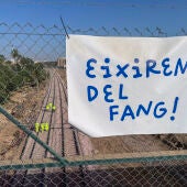 Una pancarta con la frase ¡Saldremos del barro! sobre un grupo de operarios que trabaja en la reconstrucción de las vías del tren de cercanías en Alfafar/ EFE/ Raquel Segura