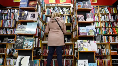 Una mujer hojea libros en un comercio de Bilbao Una mujer hojea libros en un comercio de Bilbao