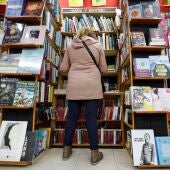 Una mujer hojea libros en un comercio de Bilbao