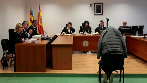 El acusado de espaldas y con la cabeza cubierta durante la vista oral El acusado de espaldas y con la cabeza cubierta durante la vista oral