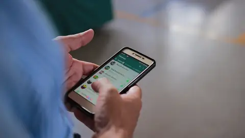Una persona usando WhatsApp. Una persona usando WhatsApp.