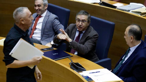 El conseller de Educaci&oacute;n, Jos&eacute; Antonio Rovira (c), realiza un gesto en presencia del portavoz del grupo parlamentario de Compromis, Joan Baldov&iacute; (i), tras su intervenci&oacute;n en Les Corts.