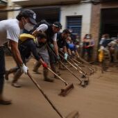 Voluntarios limpian una calle de Massanassa tras las inundaciones derivadas de la DANA de València