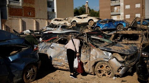 Una persona inspecciona su veh&iacute;culo en un vertedero de coches de Benetuser (Val&egrave;ncia) habilitado tras la dana. 