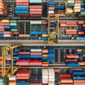 Imatge aèria d'un port amb desenes de contenidors plens de mercaderies
