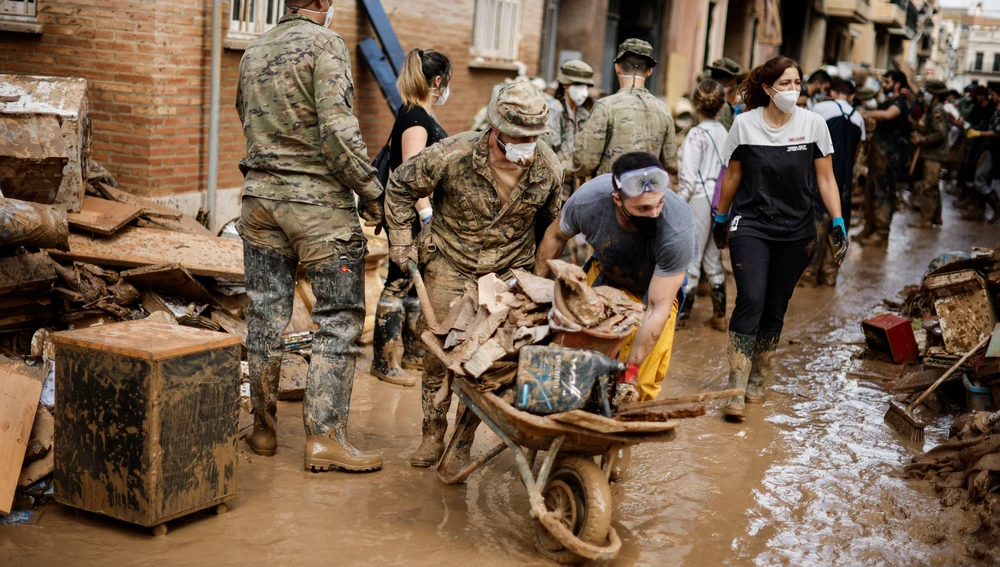 Fotografía de los trabajos tras la DANA, de la Agencia EFE, sobre la mesa al lado del Rey Fotografía de los trabajos tras la DANA, de la Agencia EFE, sobre la mesa al lado del Rey