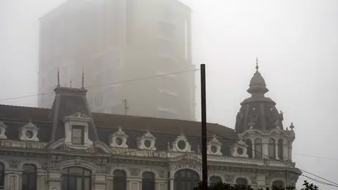 El edificio de la Jirafa entre la niebla que cubría la ciudad de Oviedo este viernes, en Asturias. El último fin de semana del año traerá tiempo estable, lluvias débiles y algunas nieblas en el interior