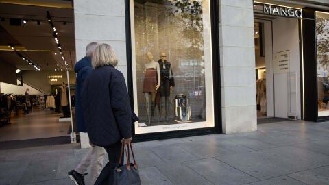 Dos viandantes pasan delante de una tienda de Mango 