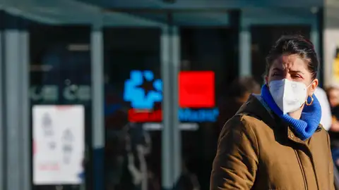 Una mujer saliendo del hospital con mascarilla Una mujer saliendo del hospital con mascarilla