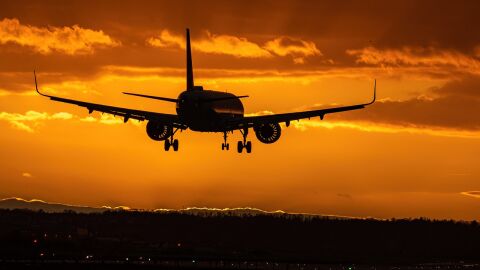 Un avión aterrizando en pleno atarceder