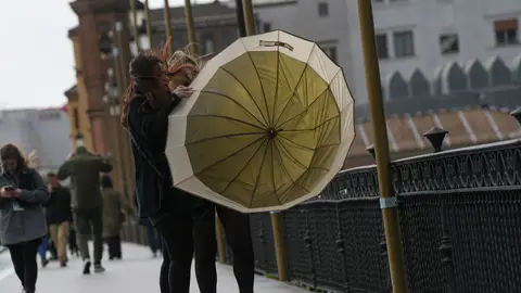 Dos mujeres luchando contra las inclemencias del tiempo en Sevilla. Dos mujeres luchando contra las inclemencias del tiempo en Sevilla.