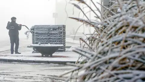 Un hombre retira la nieve y el hielo de un contenedor en la localidad abulense de Martiherrero a 12 kilómetros de la capital. Un hombre retira la nieve y el hielo de un contenedor en la localidad abulense de Martiherrero a 12 kilómetros de la capital.