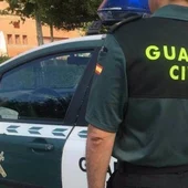 Imagen de archivo de un agente de la Guardia Civil ante un coche patrulla Imagen de archivo de un agente de la Guardia Civil ante un coche patrulla